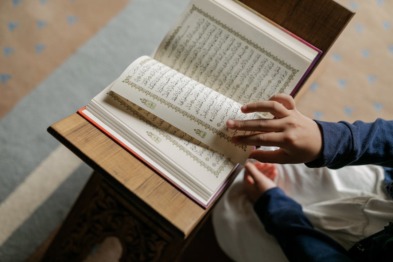 Person blättert leise in einem Mushaf.